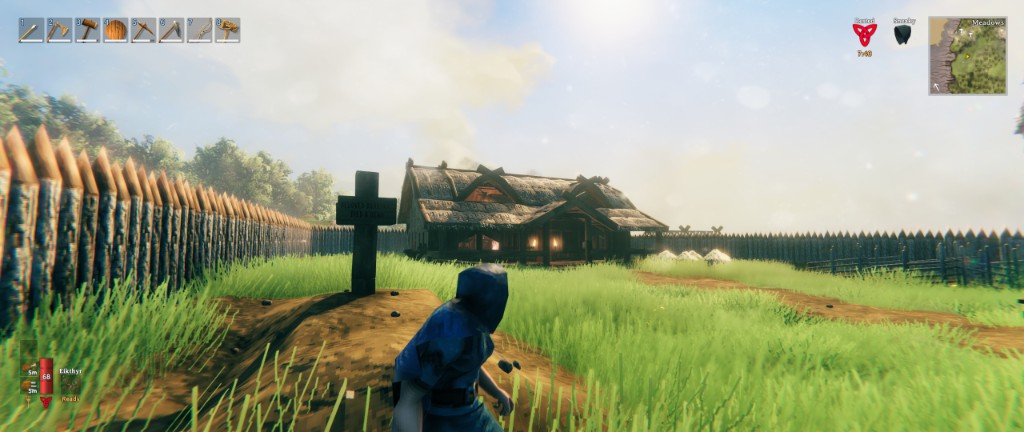 Valheim - thatched cottage and fenced yard in the Meadows, seen from behind the player character